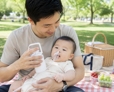 Papa utilise le mouche nez pour bébé au parc