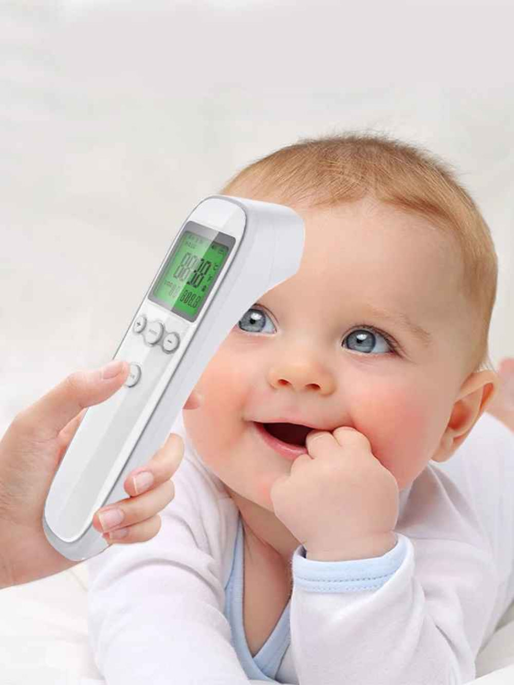 bébé souriant lorsque sa maman utilise le thermomètre frontal pour bébé